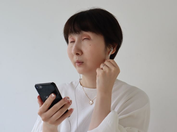 写真：バリアフリー音声ガイドを使用する女性