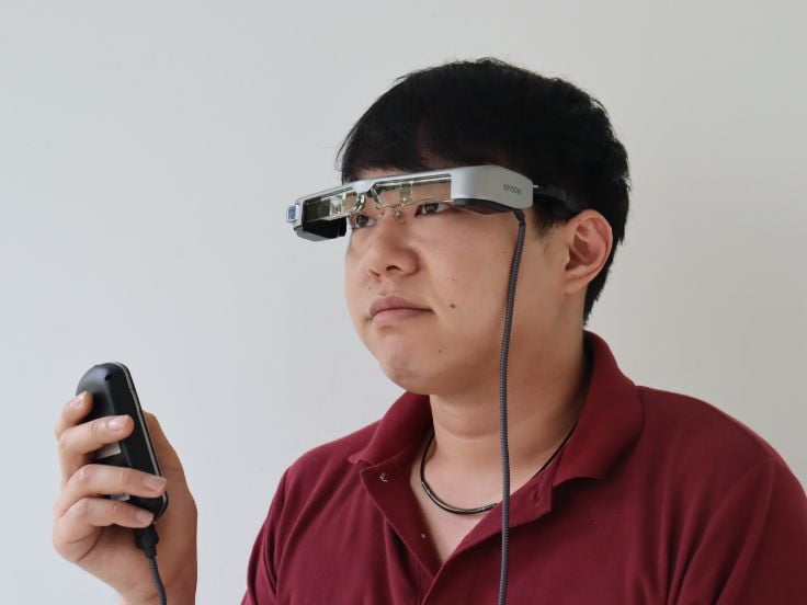 写真：メガネ型端末で聴覚障害者用字幕を使用する男性